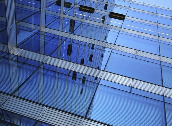 reflecting modern office building against a blue sky