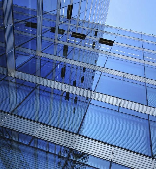 reflecting modern office building against a blue sky